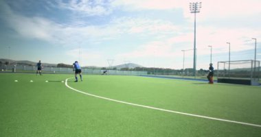 Çim hokeyi oynamak, erkek oyuncular dışarıda çim sahası çalışması. Spor, sporcular, yarışma, takım çalışması, egzersiz, eğitim