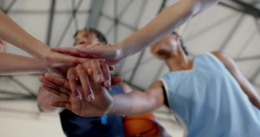 Basketbol takımı toplanıyor, maçtan önce el ele tutuşuyor, birlik gösteriyor. Takım çalışması, spor, motivasyon, hazırlık, sporcular, toplanma