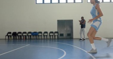 Basketbol oynuyorlar, bayan sporcular spor salonunda koçla salya akıtarak antrenman yapıyorlar. Spor, antrenman, takım çalışması, egzersiz, fitness, yarışma