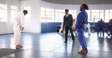 Judo antrenmanı, paspasın üzerinde antrenman yapan sporcular dojo 'da gözlemliyor. Dövüş sanatları, eğitim, dövüş