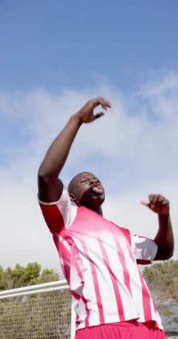 Dikey video: Sporcu dışarıda zaferi kutluyor, heyecan ve tutkuyla kolunu kaldırıyor. Kutlama, başarı, sportmenlik, zafer, hedef, coşku