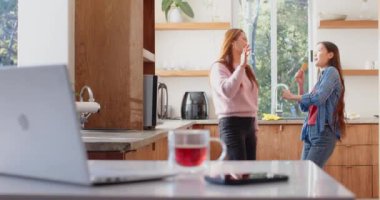 Mutfak aletleriyle şarkı söylemek, Asyalı anne ve kız mutfakta eğlenmek. Aile, eğlence, ev, yemek, bağ, mutluluk.