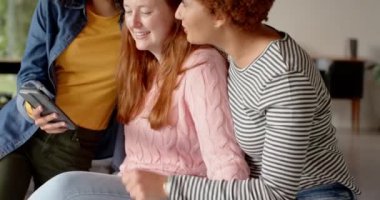 Akıllı telefonlara bakmak, gülümseyen bayan arkadaşlara evde eğlenmek. Arkadaşlık, birliktelik, bağ, eğlence, mutluluk, kahkaha