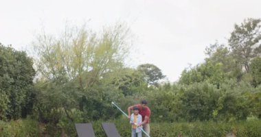 Yüzme havuzu temizleme, havuz temizleme, Hintli baba gözetiminde havuz temizleme. Bakım, aile, açık hava, yaz, takım çalışması, kaynaşma