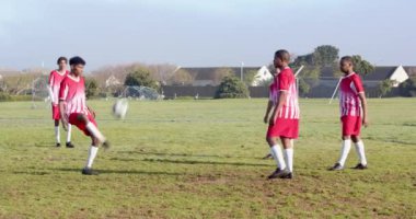 Futbol oynuyorlar, kırmızı üniformalı çocuklar okulda antrenman yapıyorlar. Spor, takım çalışması, gençlik, egzersiz, şampiyonluk