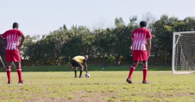 Futbol oynuyor, kırmızı üniformalı iki erkek oyuncu penaltı atışına hazırlanıyor. spor, takım çalışması, yarışma, atlet, hedef, hazırlık