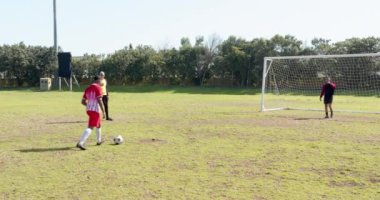 Futbol oynuyor, kaleciyle kaleye doğru topa vurmaya hazırlanıyor. spor, rekabet, atlet, takım çalışması, eylem, fitness