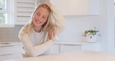 Gülümseyen kadın, saçlarını parlak mutfak ortamında düzeltiyor, fotokopi çekiyor. Portre, yaşam tarzı, mutluluk, yerli, saç stili, gelişigüzel