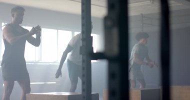 Spor salonunda egzersiz yapan, atlama hareketleri yapan ve antrenman yapan erkekler. Fitness, egzersiz, yoğunluk, dayanıklılık
