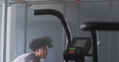 Spor salonunda kollarını uzatan adam egzersiz ekipmanlarının yanında antrenmana hazırlanıyor. Spor, eğitim, hazırlık, sağlık, sağlık