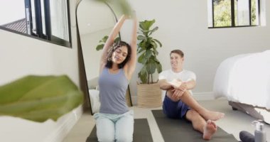 Yoga minderleri üzerinde birlikte esnemek, evde yoga yapan genç ve çok ırklı bir çift. Meditasyon, sağlık, yaşam tarzı, spor, egzersiz, sağlıklı yaşam