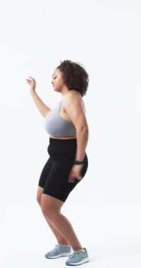 Dikey video: Aktif giyimli, gülümseyen ve beden pozitifliğini destekleyen kadın figürü. Fitness, wellness, happiness, self-love, power, dance