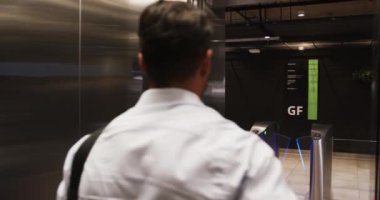 Asansöre binen, beyaz gömlekli, kapıya bakan, omuz çantası taşıyan bir iş adamı. kurumsal, banliyö, ulaşım, yürütme, profesyonel, kentsel