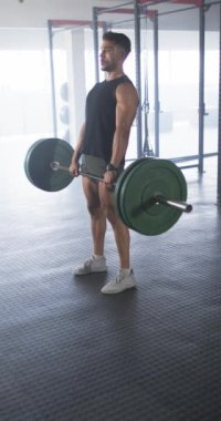 Dikey video: Ağır halteri kaldırmak, beden eğitimi için spor yapan bir adam. Fitness, vücut geliştirme, egzersiz, halter, egzersiz, kas