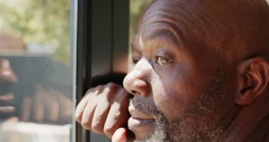 Pencereden dışarı bakan, düşüncelerini ve anılarını yansıtan dalgın bir Afro-Amerikalı. Yansıma, tefekkür, yalnızlık, düşünceli, içgözlem, nostalji.