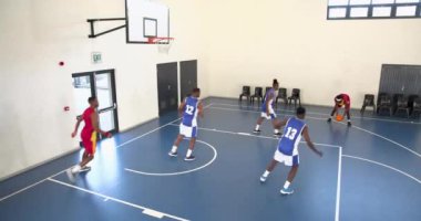 Basketbol oynayan, pas veren ve spor salonunda basketbol oynayan çok ırklı erkek basketbolcular. spor, yaşam tarzı ve etkinlik.