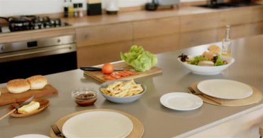 Yemek hazırlamak, sebze, patates kızartması ve çörekleri mutfak tezgahına koymak. Yemek pişirme, aşçılık, yemek hazırlama, malzemeler, yemek hazırlama, fast food