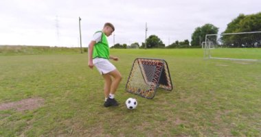 Erkek futbolcu antrenmanı, ısınma hareketleri ve sahada bacaklarıyla zıplayan top. spor, yaşam tarzı, futbol ve etkinlik.