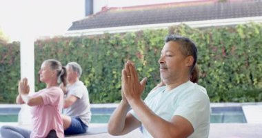 Açık havada meditasyon yapmak, üst düzey arkadaşlar havuz başında yoga yapıyor. Sağlık, rahatlama, farkındalık, meditasyon, egzersiz, fitness