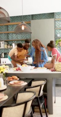 Dikey video: Birlikte öğle yemeği hazırlamak, mutlu bir ailenin modern mutfakta kaliteli zaman geçirmesi. Beraberlik, bağlılık, yemek pişirme, yemek hazırlama, aşçılık, yaşam tarzı