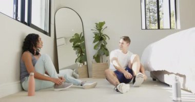 Birlikte egzersiz yapıyor, çok ırklı çiftler yatak odasında ve evde spor yapıyor. Egzersiz, ev çalışması, sağlıklı yaşam tarzı, birliktelik.