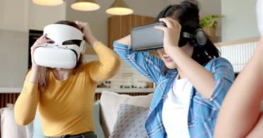 Evde sanal gerçeklik deneyimi yaşayan üç kadın arkadaş, sanal gerçeklik kulaklığı kullanıyor. teknoloji, oyun, eğlence, arkadaşlar, eğlence, sürükleyici