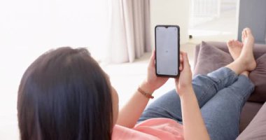 Kanepede dinlenmek, elinde akıllı telefon olan bir kadın ve evde internete göz atmak. Rahatlama, teknoloji, yaşam tarzı, rahatlık, rahatlık, gündelik