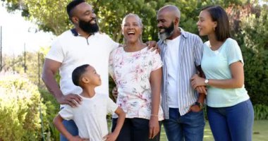 Gülümseyen Afro-Amerikan ailesi dışarıda birlikte poz veriyor, bahçede kaliteli vakit geçiriyor. Beraberlik, mutluluk, bağlanma, boş zaman, yaz, neşe