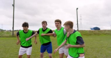 Erkek futbol oyuncuları sıraya girmiş, maç izliyor ve sahada kutlama yapıyorlar. spor, yaşam tarzı, takım çalışması, futbol ve etkinlik.