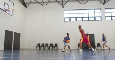 Basketbol oynayan, pas veren ve beden eğitimi veren çok ırklı erkek basketbolcular. spor, yaşam tarzı ve etkinlik.