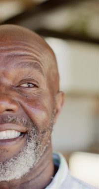 Dikey video: Mutluluk ve pozitiflik gösteren, sakallı ve gülümseyen olgun bir adam. Neşeli, neşeli, gülümseyen, mutlu, anlamlı, yaşam tarzı