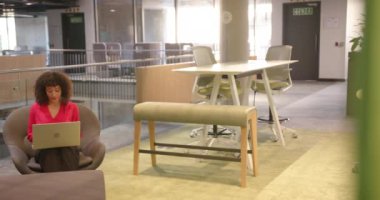 Dizüstü bilgisayarda çalışıyor, iş kadını modern ofis salonunda oturuyor. kurumsal, profesyonel, çalışma alanı