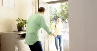 Baba eve girerken kızını sırt çantasıyla kucaklıyor ve veda ediyor. Aile, sabah, sevgi, babalık, bağlılık, duygular.