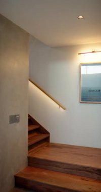 Dikey video: Ahşap basamaklı modern merdiven ve çerçeveli okyanus resimleri, rahat ev dekorasyonu. İç mimari, tasarım, çağdaş, dekoratif, stil