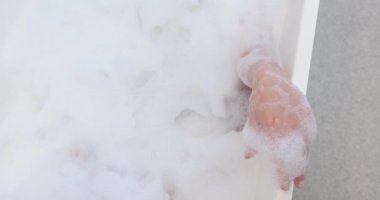 Küvette dinlenmek, köpük banyosunun ve spa tedavisinin tadını çıkaran genç bir kadın, fotokopi odası. Sağlık, rahatlama, kendine dikkat, lüks, kabarcıklar, şımartma.