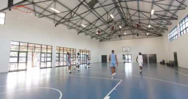 Basketbol oynayan, pas veren ve spor salonunda basketbol oynayan çok ırklı erkek basketbolcular. spor, yaşam tarzı ve etkinlik.