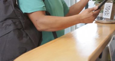 Akıllı telefonla ödeme, protez laboratuar resepsiyonunda işlemi tamamlayan kişi. Ödeme, teknoloji, sağlık, müşteri, yenilik