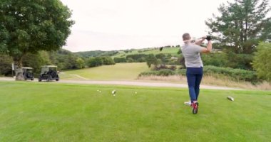 Golf oynayan erkek bir golfçü, golf sahasında golf sopasıyla topa vuruyor. spor, etkinlik ve golf.