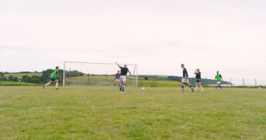 Erkek ve bayan futbolcular pas veriyor ve kaleye vuruyor, yavaş çekimde, kopyalama alanında. spor, yaşam tarzı, takım çalışması, futbol ve etkinlik