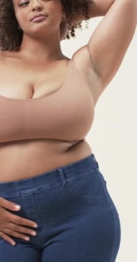 Dikey video: Gülümseme artı cüsseli kadın rahat poz veriyor, vücut pozitifliğini kucaklıyor. Özsaygı, moda, tarz, mutluluk, güç, yaşam tarzı.