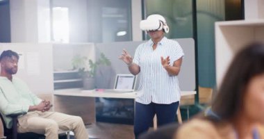 VR kulaklık, kadın ayakta ve iş arkadaşları ofiste izlerken etkileşim. Teknoloji, yenilik, takım çalışması, işbirliği, sanal gerçeklik, modern