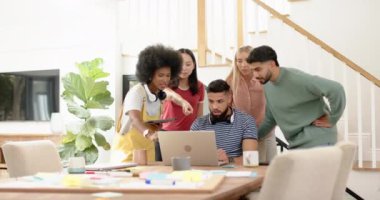 Projede işbirliği, evdeki laptop ve tableti kullanan bir grup genç arkadaş. Takım çalışması, işbirliği, teknoloji, yaşam tarzı, çalışma, beyin fırtınası.