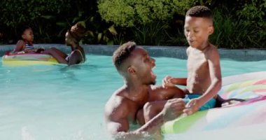 Bilardoda oynayan Afro-Amerikan baba ve oğlu yaz gününün tadını çıkarıyorlar. Eğlence, kaynaşma, açık hava, rahatlama, tatil