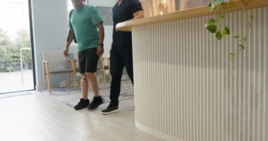 Protez bacaklı bir adam klinikte doktorla el sıkışıyor. Rehabilitasyon, sağlık, protez, fizyoterapi, el sıkışma, takım çalışması