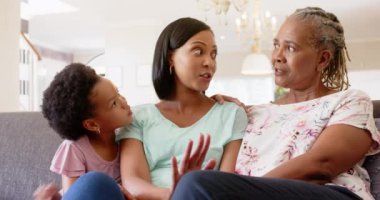 Üç nesil boyunca Afro-Amerikan kadınları kanepede oturup, evlerinde muhabbet edip kaynaştılar. Afro-Amerikan ailesi, büyükanne, anne, kız, ilişki, birliktelik