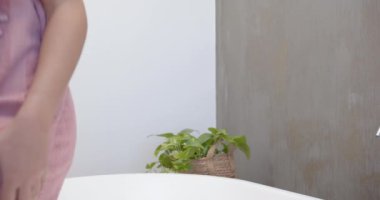 Su ısısını ayarlamak, kadınlar modern banyo kaplıcalarında su akışını test etmek. Rahatlama, sağlık, hijyen, kendine bakım, lüks, sükunet.