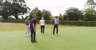 Erkek golfçüler üniforma giyiyor, golf oynuyor ve golf sahasında topa vuruyor. spor, yaşam tarzı, golf ve etkinlik.
