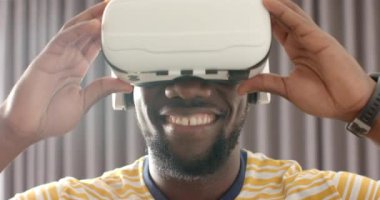 VR kulaklık takan gülümseyen adam evde sanal gerçeklik deneyiminin tadını çıkarıyor. Teknoloji, sanal eğlence, oyun, yaşam tarzı, değişmemiş, yaşam tarzı.