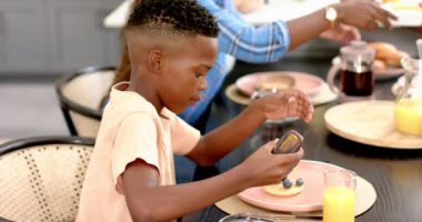 Çocuk evde yemek masasında aile yemeğinde krebine bal döküyor. Kahvaltı, birliktelik, kaynaşma, yemek, değiştirilmemiş, yavaş çekim