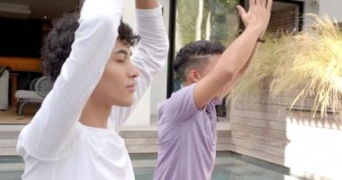 Meditasyon yapan, çok ırklı eşcinsel çift ellerini dua pozisyonu ve bahçede farkındalık egzersizi yapıyor. Meditasyon, yoga, rahatlama, maneviyat, sağlık, uyum.